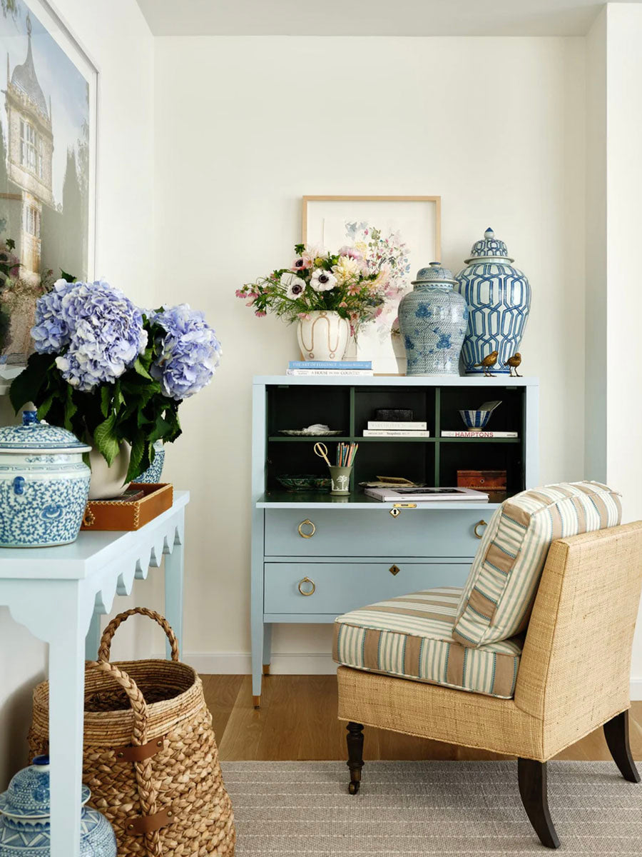 A light blue secretary desk with hinged front open to be used as a work surface.